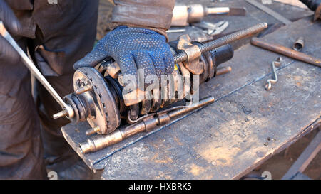 Auto mechanic working on shock absorber in garage Stock Photo