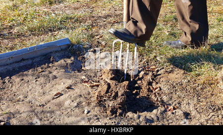 Digging spring earth soil in garden with pitchfork Stock Photo