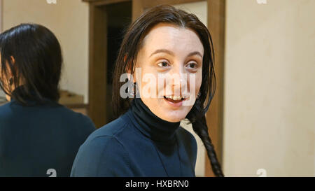 Pretty brunette woman plaits long black silky hair Stock Photo