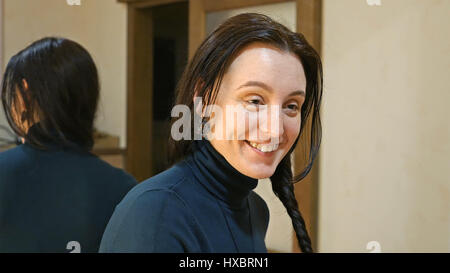 Pretty brunette woman plaits long black silky hair Stock Photo