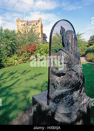 Guildford Surrey UK Lewis Carroll character Alice Through the Looking Glass statue displayed in public gardens ruins of Guildford Castle beyond Stock Photo