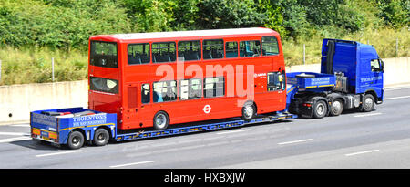 Arriva London bus red double decker  transportation on a low loader transporter travelling slowly transporting along m25 motorway in Essex England UK Stock Photo