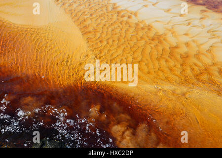 Patterns in a tannin-stained creek flowing over white sand at Abraham's Bosom Reserve, Currarong, Jervis Bay, Shoalhaven, New South Wales,  Australia Stock Photo