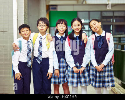 portrait of a group of happy and smiling elementary school students in uniform. Stock Photo
