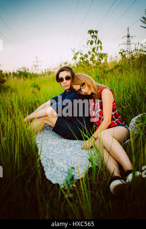 guy and the girl sitting in the grass Stock Photo