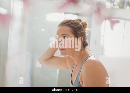Woman with hand in hair in bathroom Stock Photo