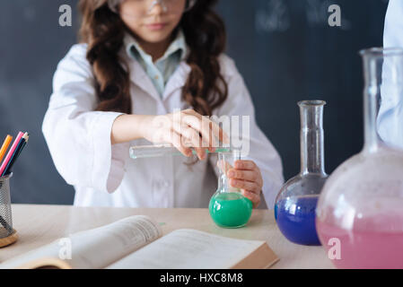 Capable teenagers taking part in the chemistry experiment at school Stock Photo