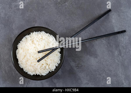 Bowl of rice and chopsticks isolated on white background with selective focus Stock Photo