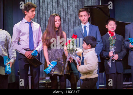 Commerce Township, Michigan - High school students are given roses for raising funds for children affected by war in Syria. Omar and Ziad Fehmi, whose Stock Photo