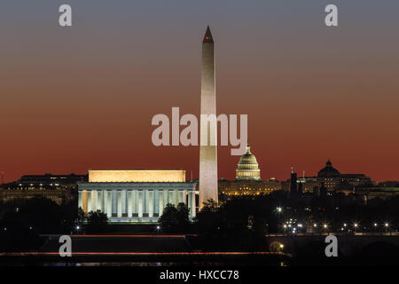 The Lincoln Memorial, Washington Monument, and US Capitol building set against an orange sky during morning twilight in Washington, DC. Stock Photo