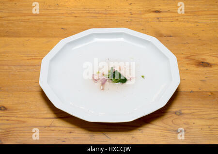 Empty plate after eating salad  on a wood table Stock Photo