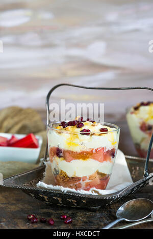 White chocolate mousse with poached rhubarb garnished with pomegranate seeds Stock Photo