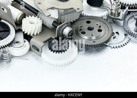 parts of industrial equipment closeup. plastic gears and cogwheels on scratched metal background. Stock Photo