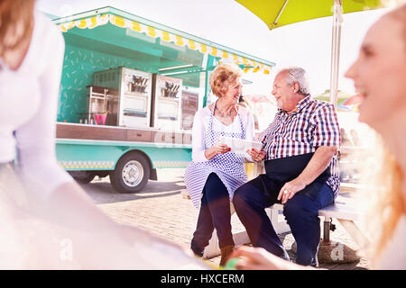 Smiling senior business owners using digital tablet outside food cart Stock Photo