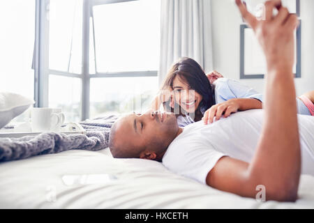 Smiling couple laying and relaxing on bed Stock Photo