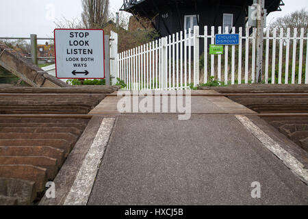 Rye, Unmanned railway crossing with sign showing the dangers of crossing cyclists dismount stop look listen look both ways Rye East Sussex Stock Photo