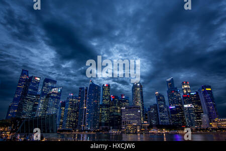 Moon light shinning through clouds over the city scape of Singapore. Stock Photo