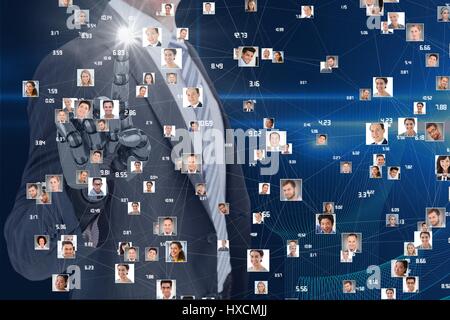 Digital composite of Business man with robotic hand interacting at screen with flying portraits Stock Photo