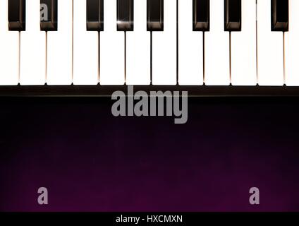 Digital composite of Piano keys against purple background Stock Photo