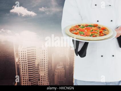 Digital composite of Chef with pizza against blurry skyline Stock Photo