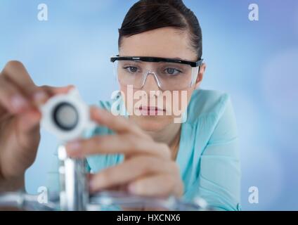 Digital composite of Close up of woman with electronics against blurry blue background Stock Photo