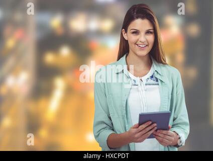 Digital composite of Young woman with tablet against Night city Stock Photo