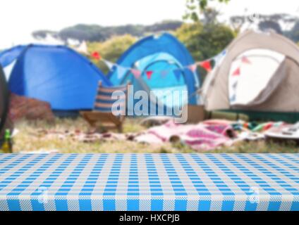 Digital composite of Picnic table against blurry campsite Stock Photo