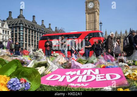 London, UK. 27th March 2017. Police Officers look at floral tributes laid in Parliament Square following the terror attack in Westminster. Credit: claire doherty/Alamy Live News Stock Photo
