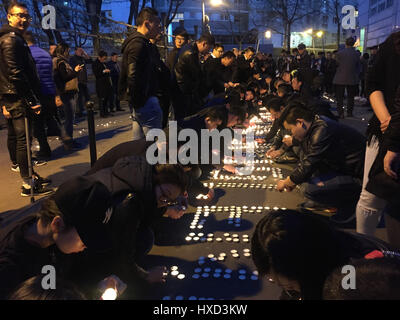 Paris, France. 27th Mar, 2017. Protestors place candles to mourn for the death of a Chinese national in Paris, France, March 27, 2017. About 100 people from the Chinese community held a demonstration Monday evening in front of a police station in the 19th arrondissement of Paris to protest against police killing of a Chinese national in a conflict Sunday night. Credit: Han Bing/Xinhua/Alamy Live News Stock Photo