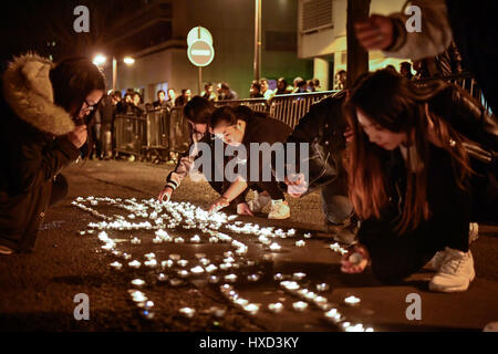 Paris, France. 27th Mar, 2017. Protestors place candles to mourn for the death of a Chinese national in Paris, France, March 27, 2017. About 100 people from the Chinese community held a demonstration Monday evening in front of a police station in the 19th arrondissement of Paris to protest against police killing of a Chinese national in a conflict Sunday night. Credit: Chen Yichen/Xinhua/Alamy Live News Stock Photo