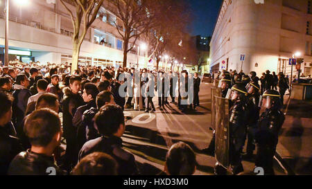 Paris, France. 27th Mar, 2017. Demonstrators and police force are seen in front of a police station in Paris, France, March 27, 2017. About 100 people from the Chinese community held a demonstration Monday evening in front of a police station in the 19th arrondissement of Paris to protest against police killing of a Chinese national in a conflict Sunday night. Credit: Chen Yichen/Xinhua/Alamy Live News Stock Photo