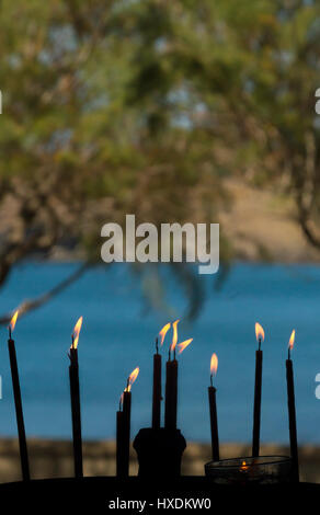 Lit candles in a small coastal chapel in Lesvos island, Greece. Stock Photo