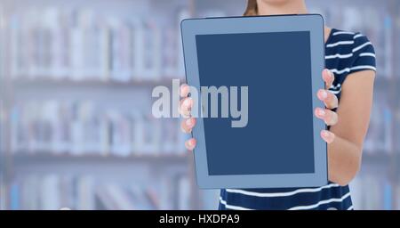 Digital composite of Womans hands holding tablet in Library Stock Photo