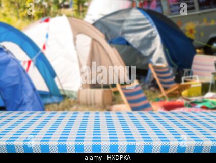 Digital composite of Picnic table against blurry campsite Stock Photo
