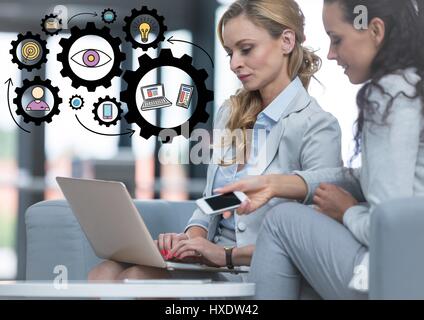 Digital composite of Two business women with laptop and black gear graphics Stock Photo