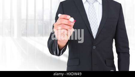 Digital composite of Business man mid sections with pen against blurry window Stock Photo