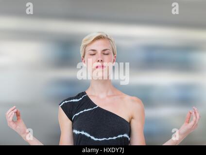 Digital composite of Woman Meditating peaceful against motion blur background Stock Photo