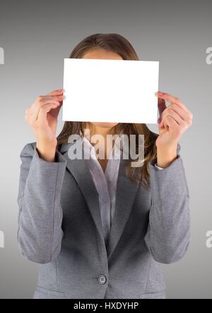 Digital composite of Business woman with blank card over face against grey background Stock Photo