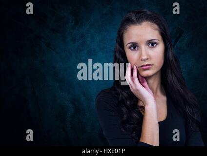 Digital composite of Unhappy doubtful woman against dark blue background Stock Photo