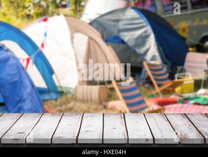 Digital composite of White wood table against blurry campsite Stock Photo