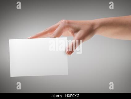 Digital composite of Hand with blank card against grey background Stock Photo