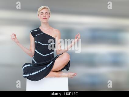 Digital composite of Woman Meditating peaceful against motion blur background Stock Photo