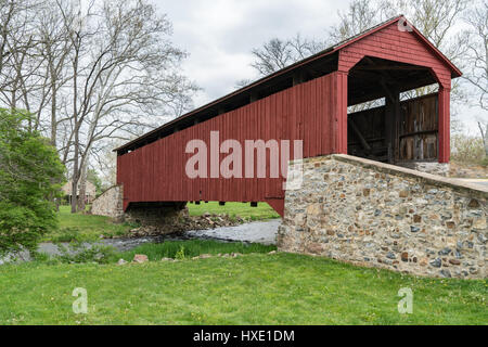 Red covered bridge in the rural countryside of Lancaster County, Pennsylvania. Stock Photo