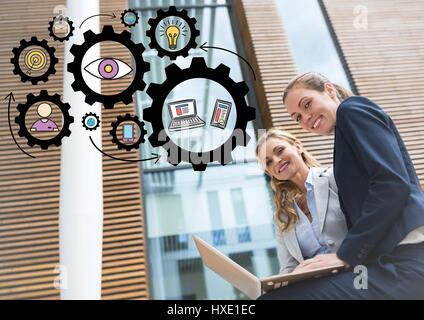 Digital composite of Two business women looking into camera with laptop and black gear graphics Stock Photo