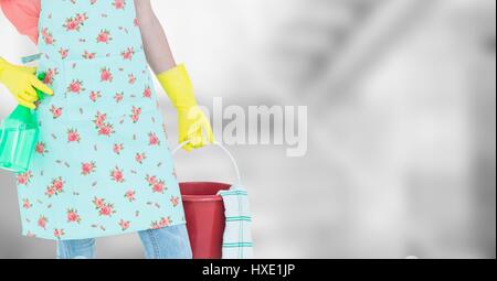 Digital composite of Woman lower body in apron with bucket against blurry grey background Stock Photo