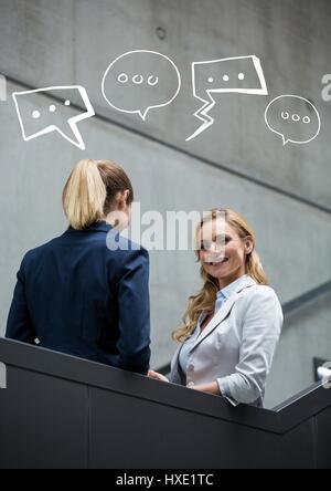 Digital composite of Business women on stairs with white speech bubbles Stock Photo