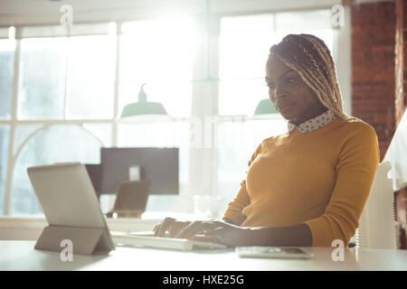 Female executive working on digital tablet at desk in office Stock Photo