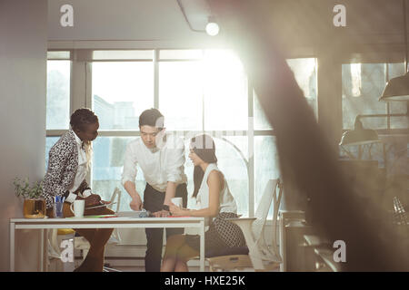 Group of executives discussing over digital tablet at office Stock Photo
