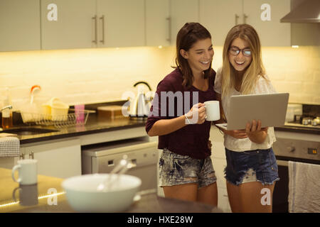 Happy friends using laptop while having coffee at home Stock Photo