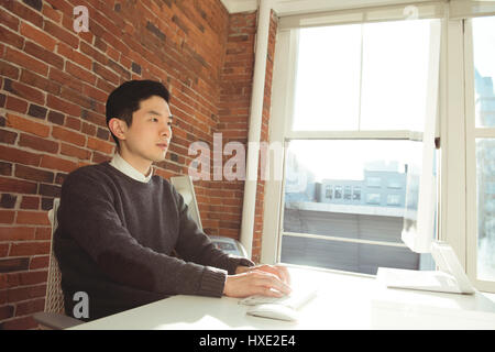 Male executive working on computer at desk in office Stock Photo